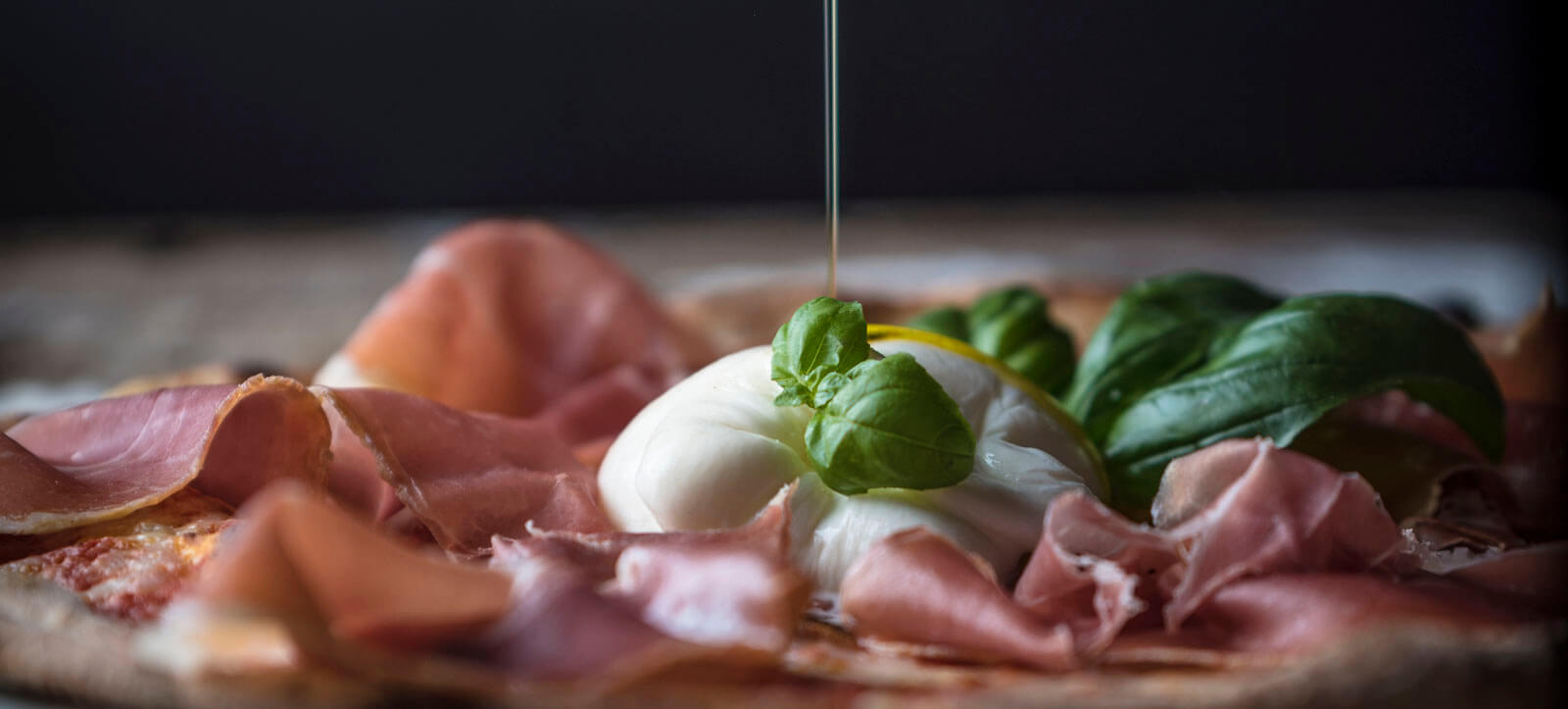 Pizza con prosciutto crudo, burrata e basilico ad Alpina 1954